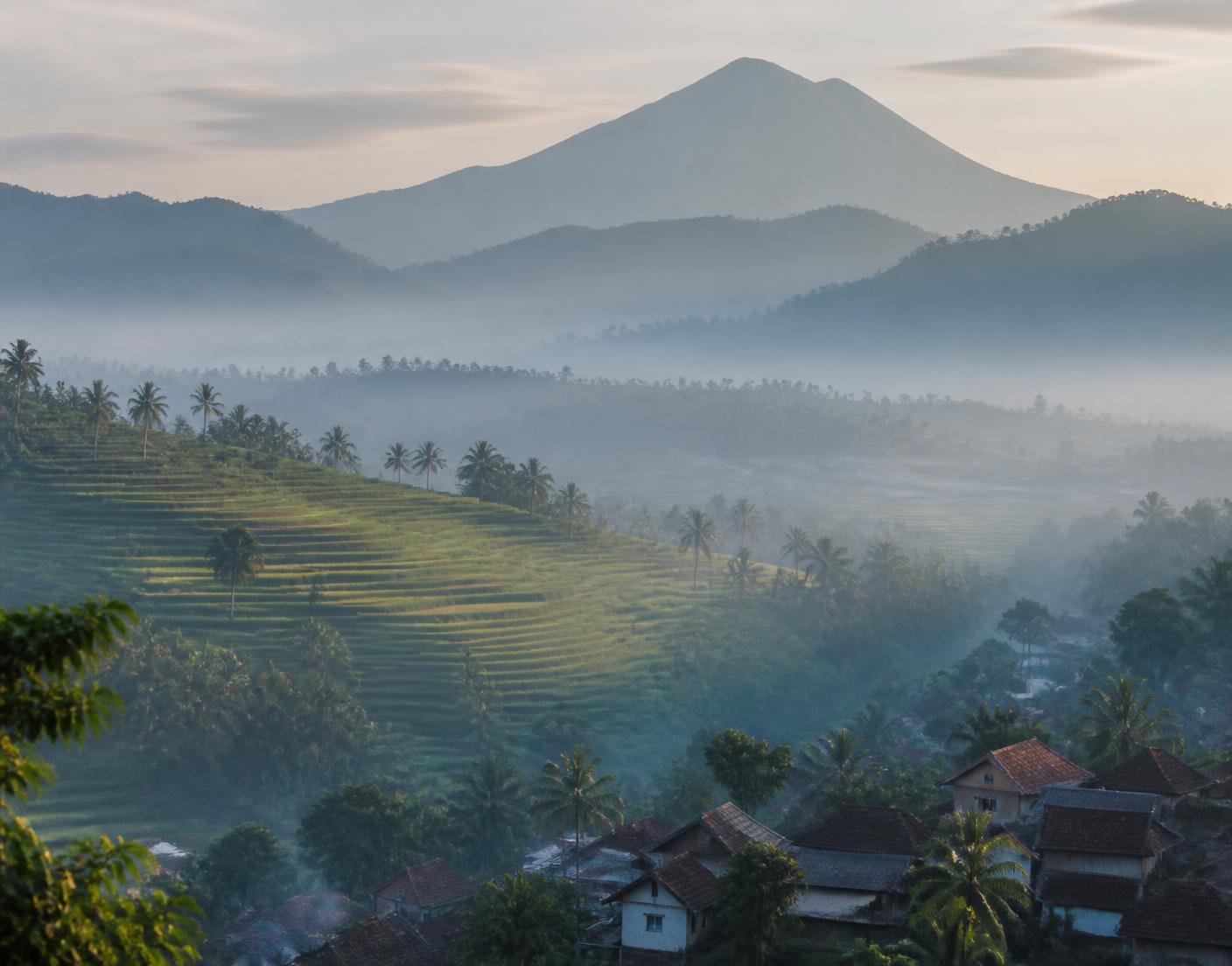 Softly lit Indonesian hillside village at dawn